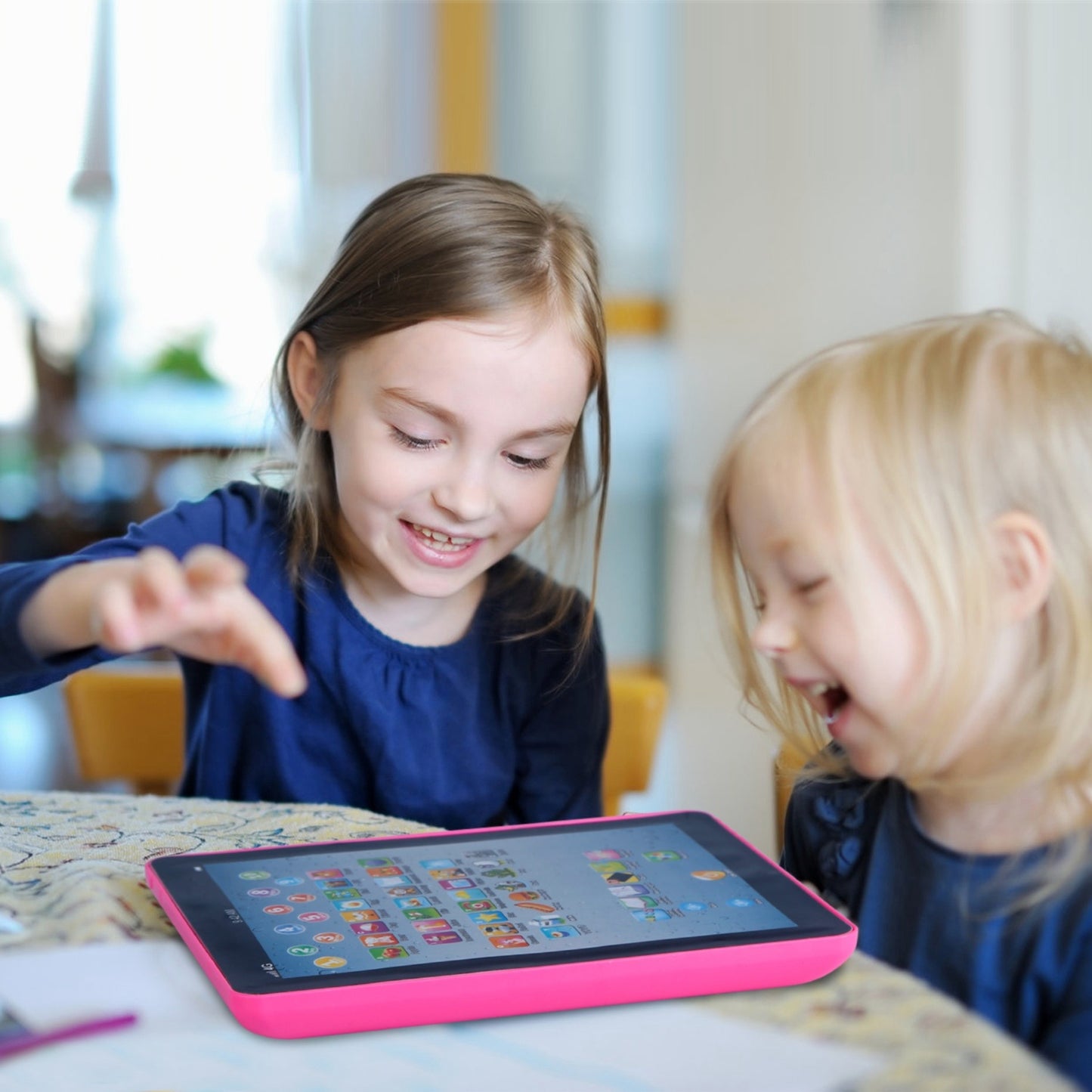 Children using an educational tablet for learning activities at home.