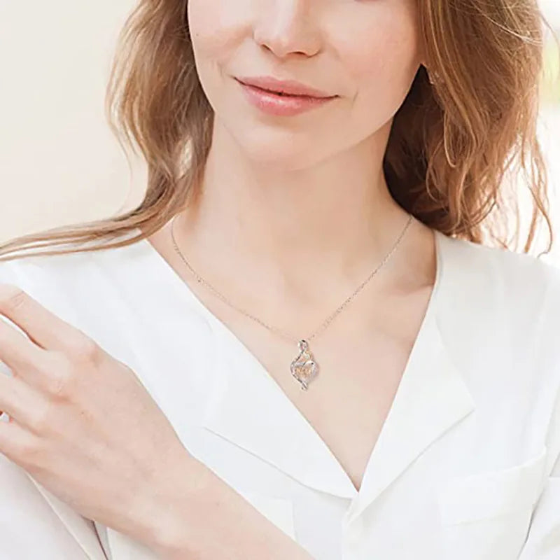 Woman wearing a delicate necklace with a heart pendant against a neutral background