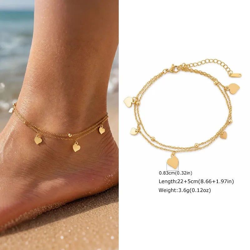 Gold anklets on a foot with beach background and bracelet details.