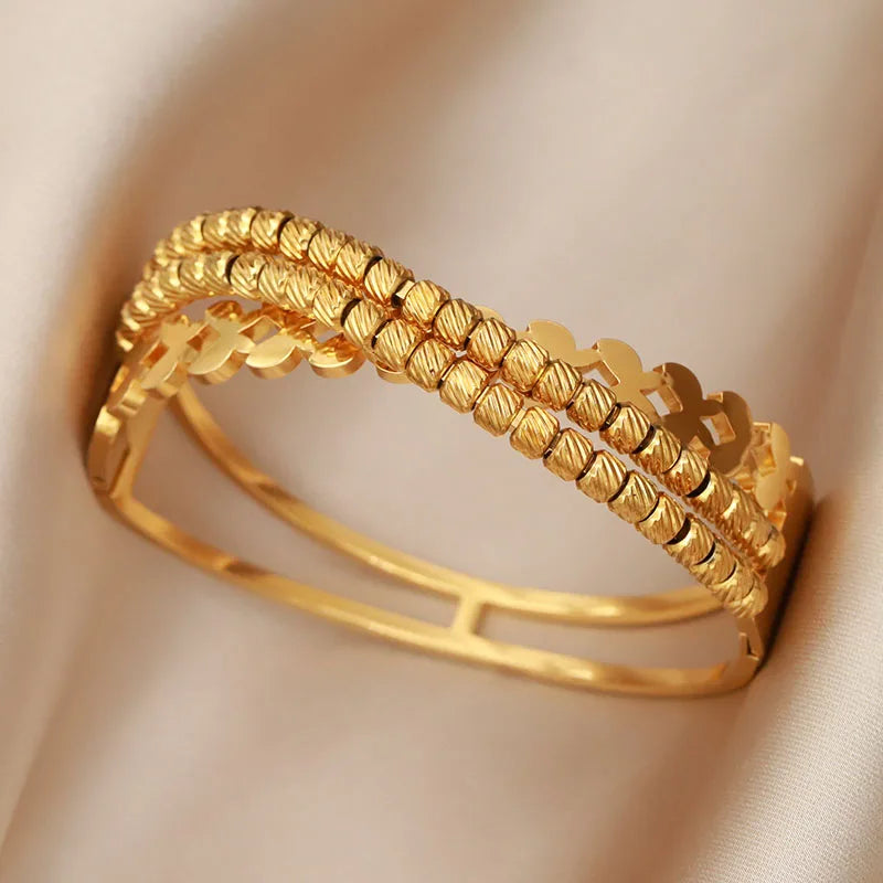 Gold bracelet on a beige fabric background