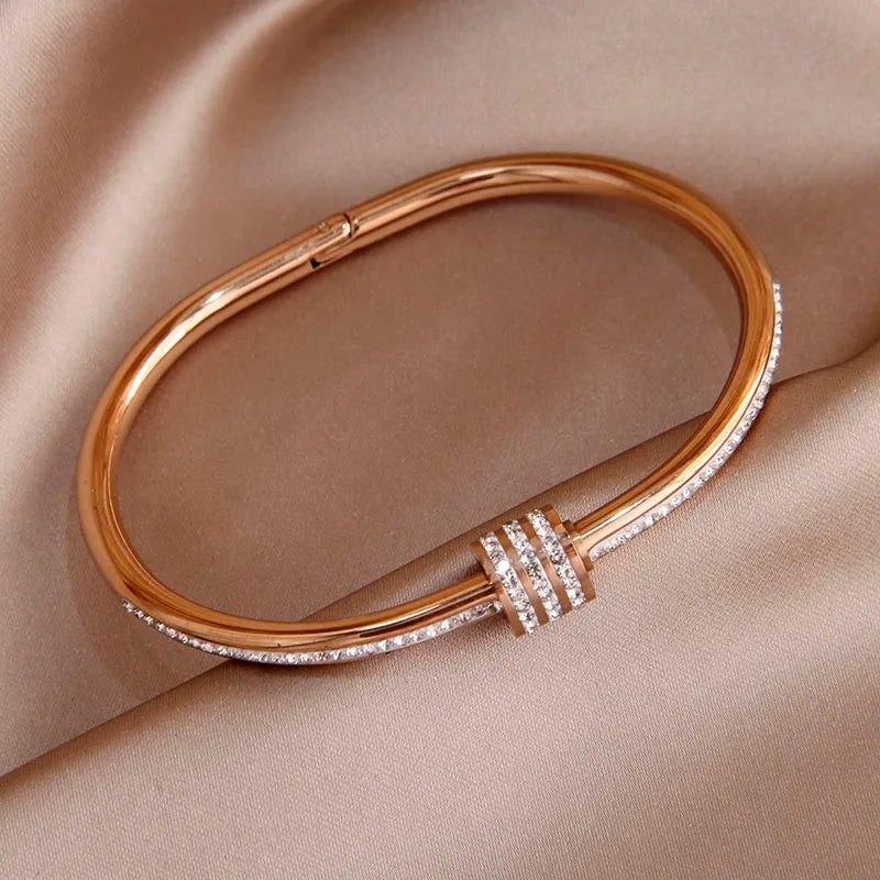Rose Gold bracelet with diamond accents on a beige fabric background