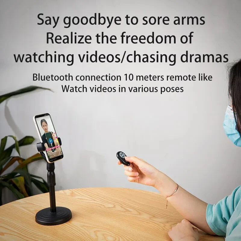 Person using a smartphone holder with Bluetooth remote on a table, with text about its features.