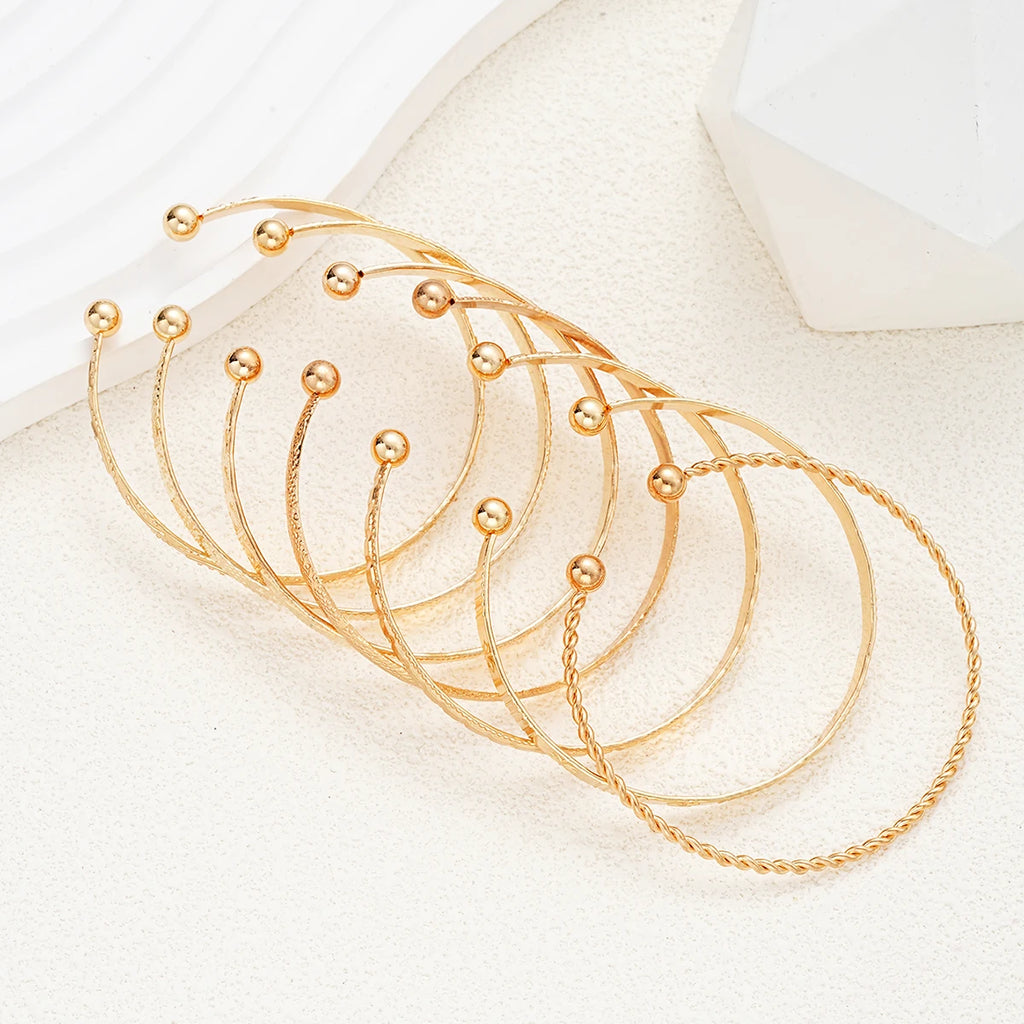 Set of gold bracelets on a white surface