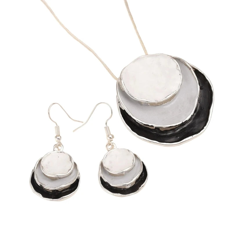 Jewelry set with necklace and earrings featuring white stones on a white background