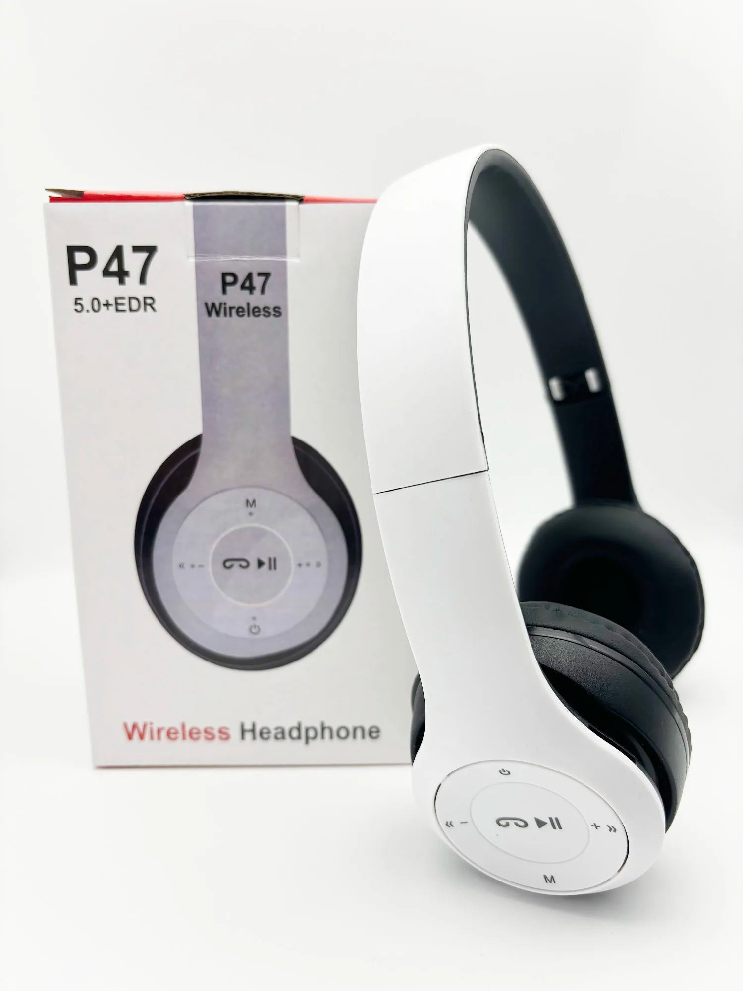 White wireless headphones with black ear cushions next to their packaging on a white background