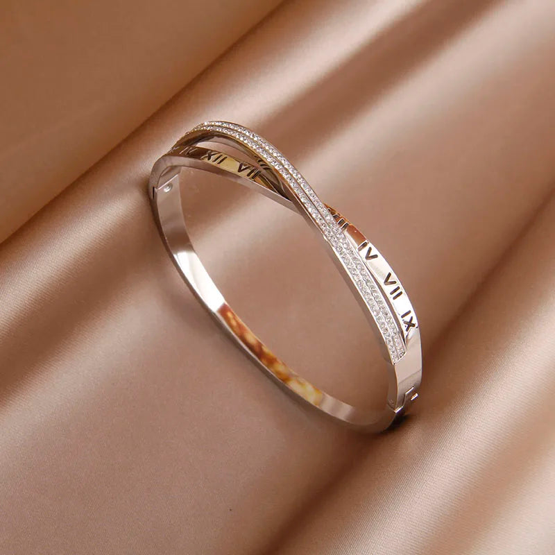 Silver bracelet with Roman numeral design on a beige fabric background