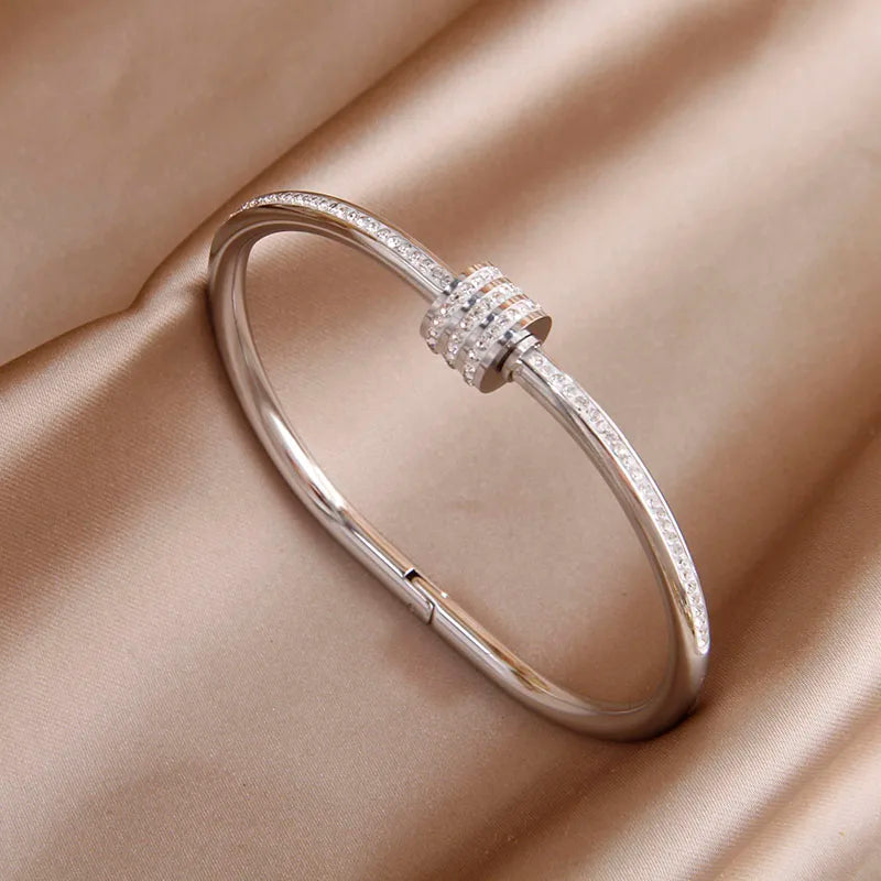 Silver bracelet with a decorative clasp on a beige fabric background
