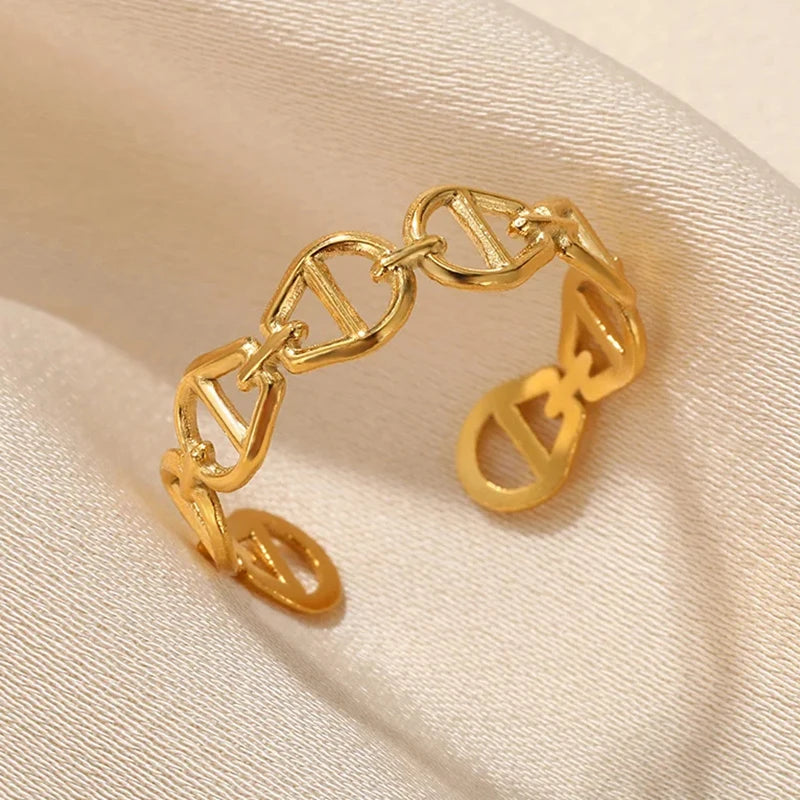 Gold chain link adjustable ring on beige fabric background