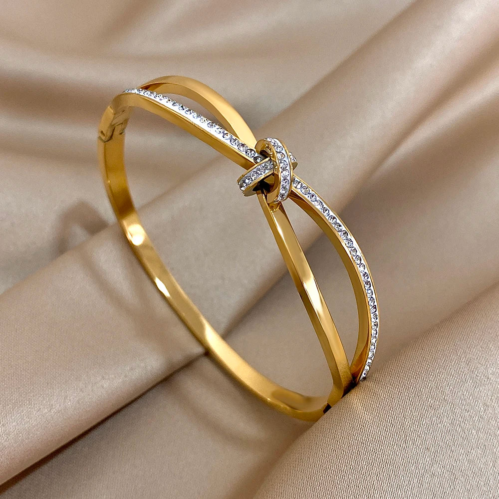 Gold bracelet with diamond accents on a beige fabric background