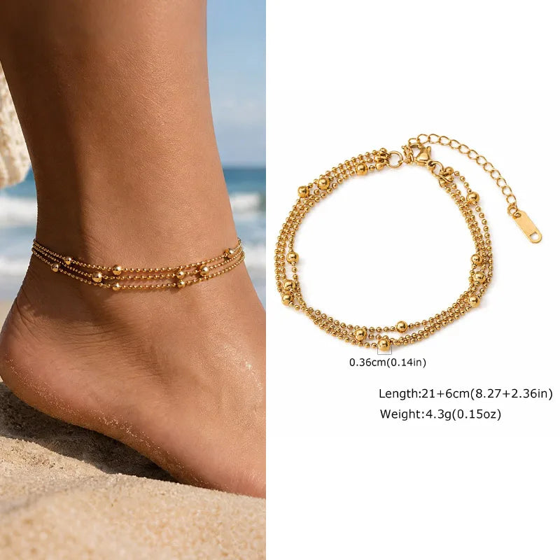 Gold anklet on a foot with beach background and close-up of anklet details.