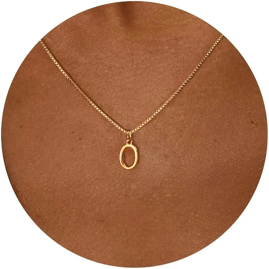 Gold necklace with a pendant on a brown circular stand