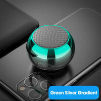 Mini orb speaker glowing while placed on mobile device
