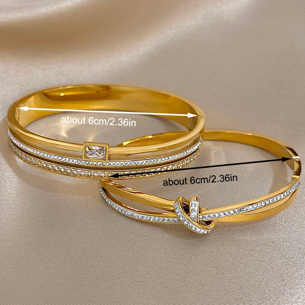 Two gold bangles with diamond accents on a beige fabric background, showing measurements.