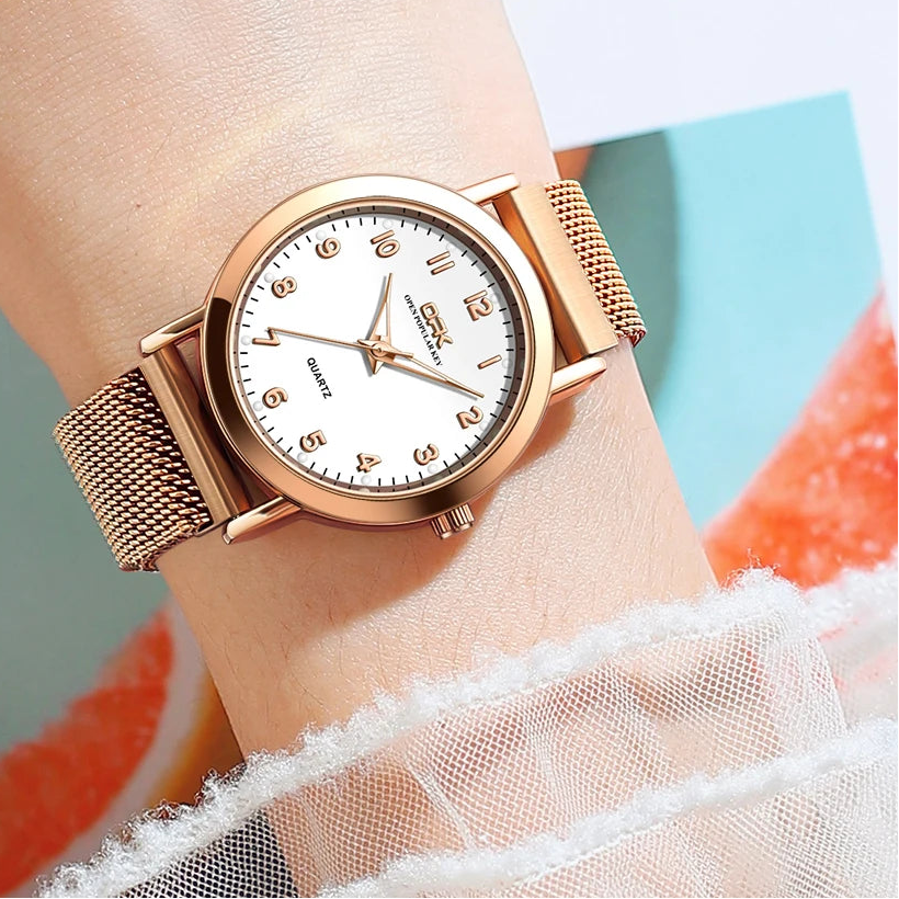 Rose gold mesh bracelet watch worn on a wrist