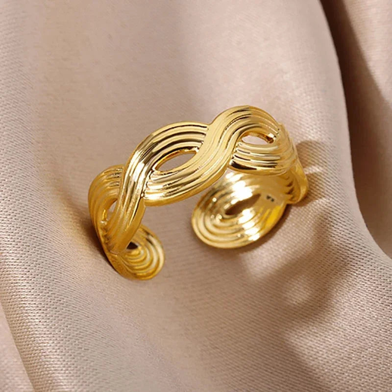 Gold ring with a textured design on a beige fabric background