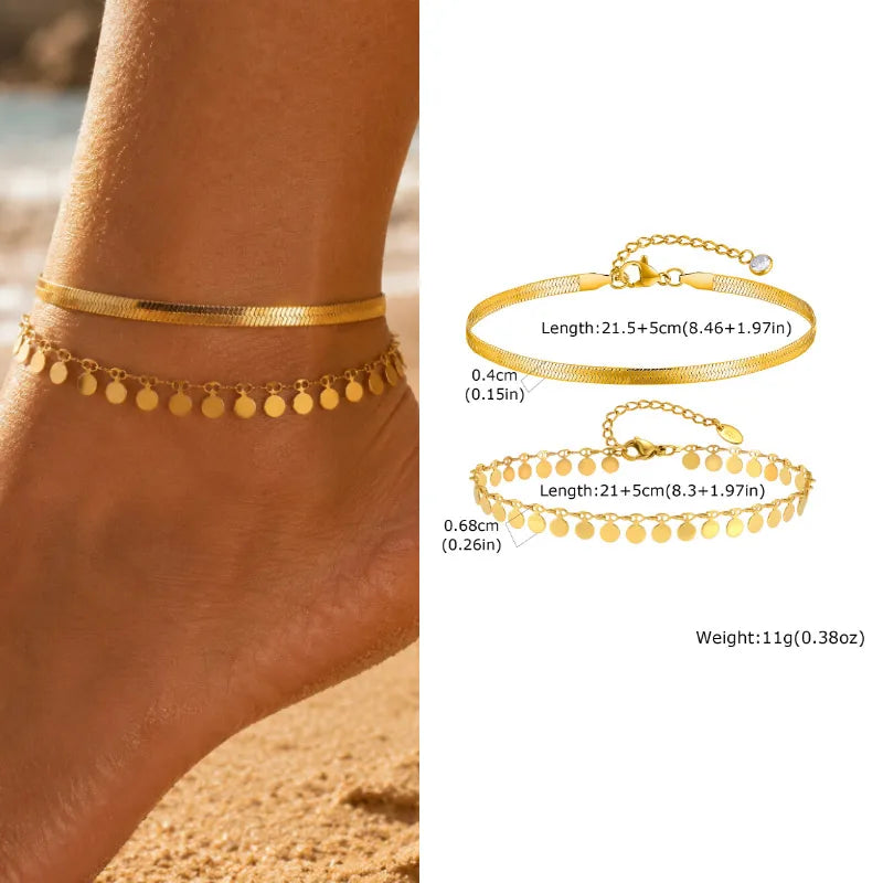 Gold anklets on a foot with product details on a white background