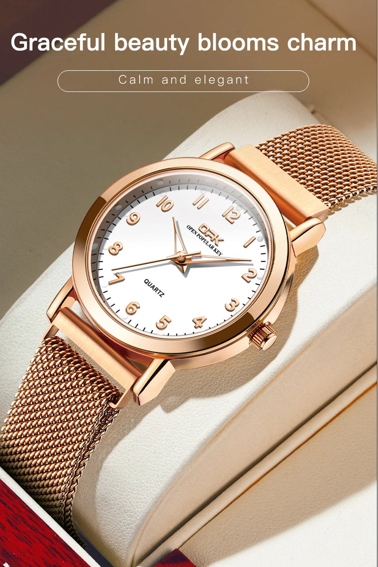 Close-up of rose gold watch with white dial and mesh band