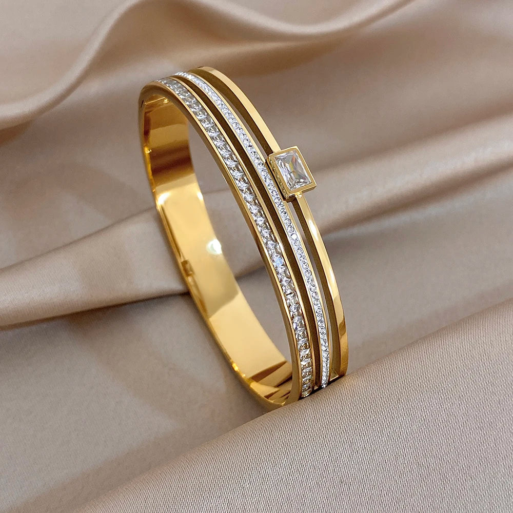 Gold bracelet with diamond on a beige fabric background